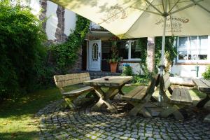 a picnic table and an umbrella in front of a house at Landgasthof Schlotmann in Welver