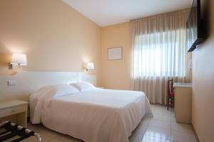 ein Hotelzimmer mit einem weißen Bett und einem Fenster in der Unterkunft Barion Hotel & Congressi in Bari + 37 Fotos