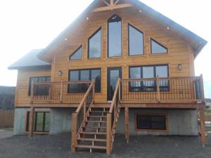 a large wooden house with stairs and windows at #1 Le refuge et #2 Le Gite in Saint-Onésime