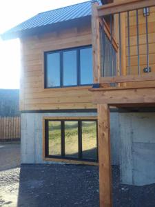 a house with a deck with windows on it at #1 Le refuge et #2 Le Gite in Saint-Onésime