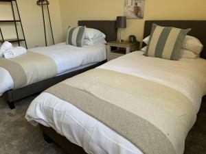 a bedroom with two beds and a table with a lamp at HS2 & NEC Ideal Location in Birmingham +3 photos