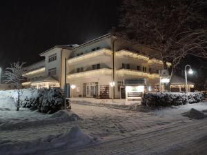 a large building in the snow at night at Hotel Nordkap in Ostseebad Karlshagen
