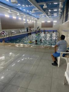 a man sitting on a chair in a swimming pool at RAHMAT yurts in Bishkek