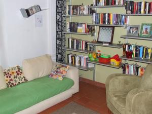 een woonkamer met een bank en boekenplanken bij Garden House in Florence