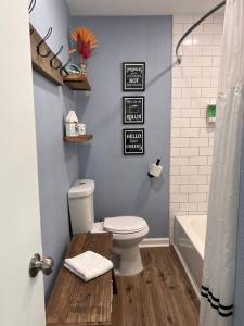 a bathroom with a toilet and a bath tub at The Mark at Surfside #7 in Surfside Beach