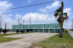 a blue building with a palm tree in front of it at The Mark at Surfside #7 in Surfside Beach
