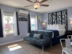 a bedroom with a bed and a chair and a ceiling fan at The Mark at Surfside #7 in Surfside Beach