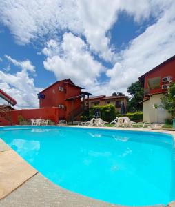 a large blue swimming pool in front of a building at Villa Zen Pirenópolis Conforto e Bem-Estar in Pirenópolis
