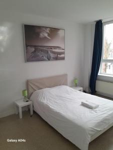 a bedroom with a white bed and a window at The Boulevard Apartment sleeps 4 in Brussels