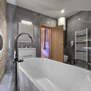a large white bath tub in a bathroom at Trebevićki Raj 1 in Brus +16 photos