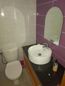 a bathroom with a white toilet and a sink at Brisa Mar Apartamento in Praia Baixo