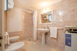 Un baño con lavabo, inodoro y espejo. en Sun Beach Villa, en Marina di Mancaversa 26 fotos más