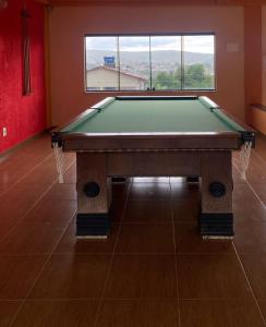a pool table in a room with a large window at Villa Zen Pirenópolis Conforto e Bem-Estar in Pirenópolis