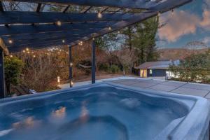 a hot tub in a backyard with a pergola at HotTub, FirePit, Pets, Pool Table, Outdoor Dining in Hendersonville