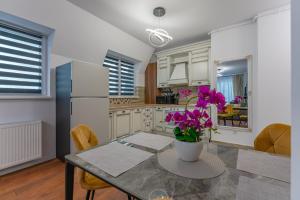 a kitchen with a table with a vase of flowers on it at Penthouse Mountain View in Râşnov