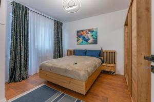 a bedroom with a bed and a large window at Penthouse Mountain View in Râşnov