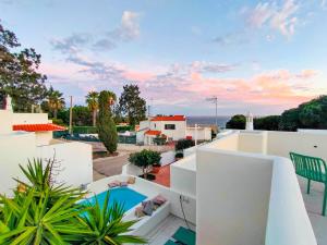 Blick vom Balkon eines Hauses mit Swimmingpool in der Unterkunft Villa Esperança in Porches