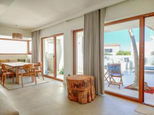 ein Wohnzimmer mit Tisch und Stühlen und Glasschiebetüren in der Unterkunft Villa Esperança in Porches