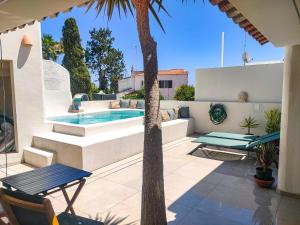 eine Terrasse mit einem Pool und einer Palme in der Unterkunft Villa Esperança in Porches
