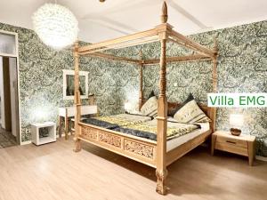 a bedroom with a canopy bed with green wallpaper at Group Villa EMG Münster Riesenbeck Osnabruck - Saerbeck in Saerbeck