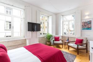 Un dormitorio con una cama y un televisor de pantalla plana. en Alegria 283, en Oporto