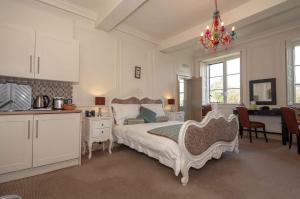 a bedroom with a bed and a desk and a kitchen at Bagshaw Hall in Bakewell +205 photos