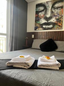 Un dormitorio con una cama con toallas. en Studio próximo ao teatro Renault e hospitais, en São Paulo