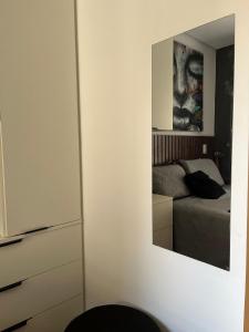 Un dormitorio con una cama y un espejo en la pared. en Studio próximo ao teatro Renault e hospitais, en São Paulo