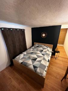 a small bedroom with a bed with a black and white comforter at Beau studio dans le centre de Bourges historique ! in Bourges