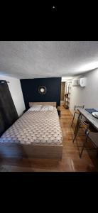 a bedroom with a bed with a blue headboard and a table at Beau studio dans le centre de Bourges historique ! in Bourges