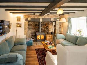 a living room with blue couches and a fireplace at Pass the Keys Cosy cottage hideaway set in beautiful countryside in Hopesay