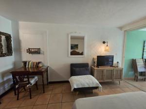 a room with a bedroom with a desk and a television at Studio Ti Coco in Sainte-Anne