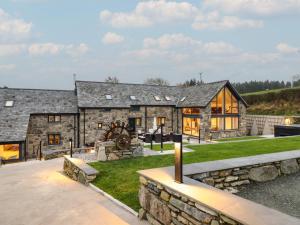 an exterior view of a stone house with a yard at Y Côr in Corwen
