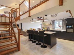 cocina y sala de estar con escalera y barra en Merddwr, en Corwen