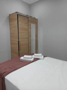 a bed with two folded towels on top of it at Chios Cozy Apartment 1 in Sklaviá