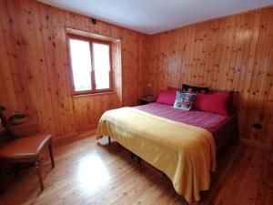 a bedroom with wooden walls and a bed with a window at Appartamento sul Liro in Campodolcino