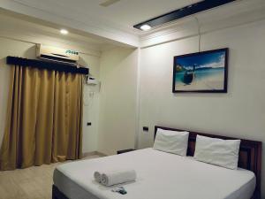 a bedroom with a bed and a picture on the wall at Cyprian Holiday Homes in Calangute
