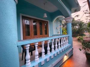 a blue house with a white railing on a balcony at Cyprian Holiday Homes in Calangute