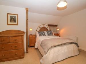 ein Schlafzimmer mit einem Bett, einer Kommode und zwei Lampen in der Unterkunft 3 Cumberland Cottages in Kingsbridge
