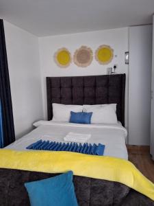 a bedroom with a large bed with blue and yellow sheets at Lymak Studio airbnb in Ongata Rongai 