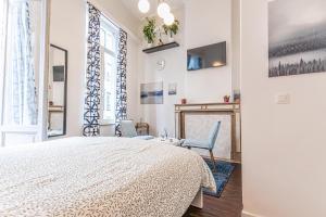 a bedroom with a bed and a chair and a fireplace at Beautiful Serenity Stylish Shared Apt at Ghent's Central in Ghent +46 photos