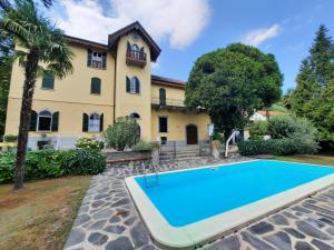 a house with a swimming pool in front of it at Villa Santa Chiara Lesa - appartamento vista lago con piscina in Lesa