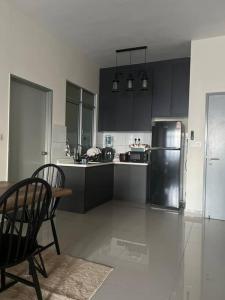 Una cocina con refrigerador y una mesa y sillas. en Kajang MRT suites, en Kajang 10 fotos más
