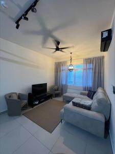 Una sala de estar con un sofá y un ventilador de techo. en Kajang MRT suites, en Kajang
