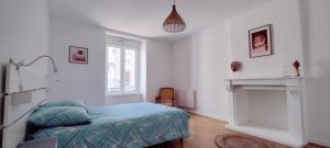 a bedroom with a bed and a fireplace at Le Corsaire in Granville