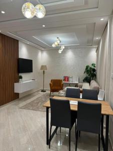 una camera con tavolo e sedie e un soggiorno di Appartement Moderne a Meknès Altre 5 foto