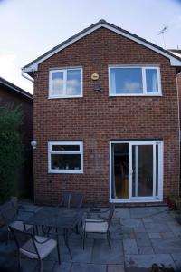 a brick house with tables and chairs in front of it at Entire 3-bed house near Cheltenham racecourse and town in Gloucestershire