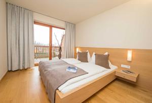 a bedroom with a large bed and a large window at Appartement Haus Sonne in Zell am See