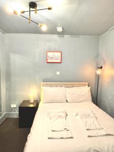 a bedroom with a bed and a table with a lamp at London Collection - Bayswater in London