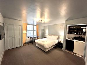 a bedroom with a bed and a desk and a window at London Collection - Bayswater in London